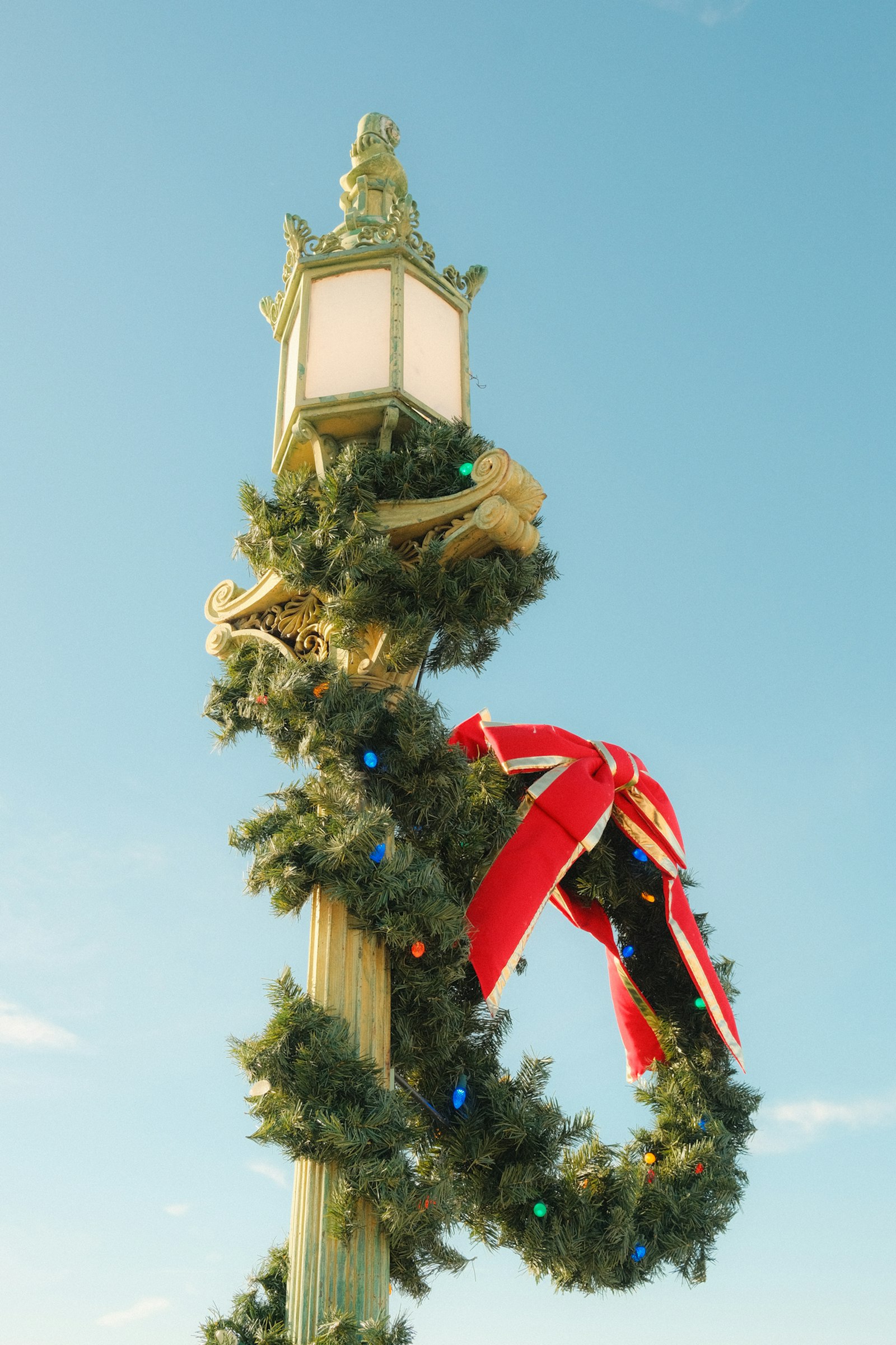 A downtown Redstone lamp post wrapped in holiday garland, twinkle lights and a red bow.